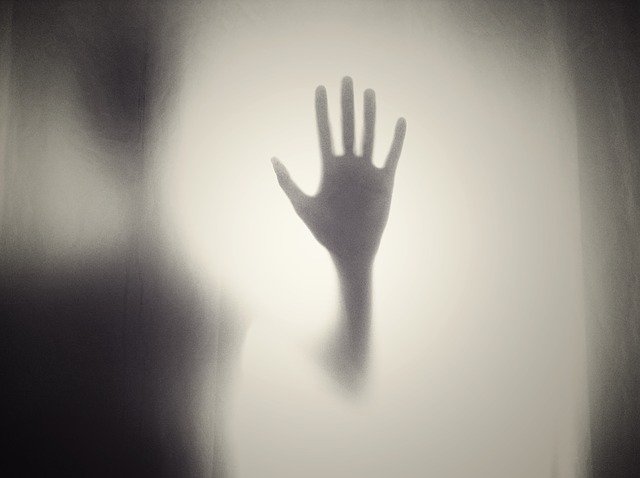 A scary hand on a pane of glass