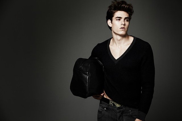 A man holding a bag and looking angsty