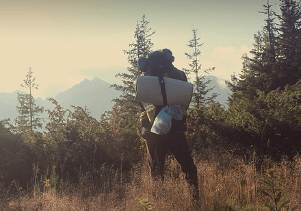 Man with a sleeping bag in nature