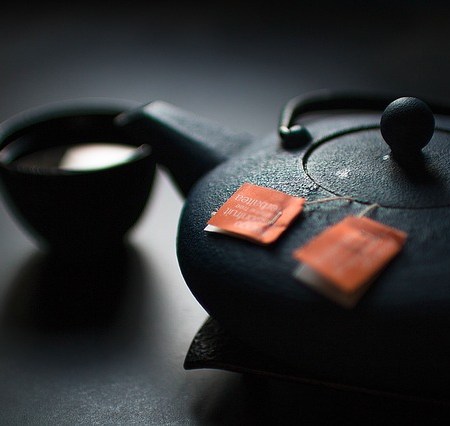 Teapot with some tea stewing and a cup