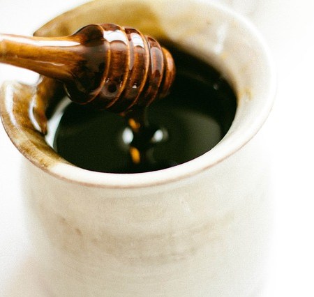 Honey being spooned out of a cup