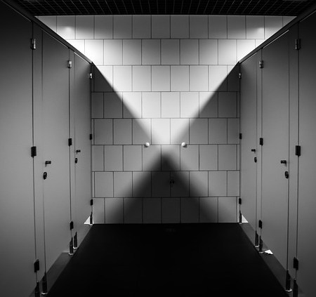 Toilet cubicles in a black and white bathroom
