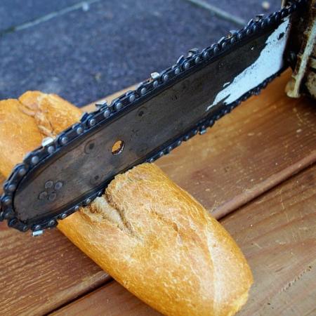 A chainsaw cutting into a baguette-min