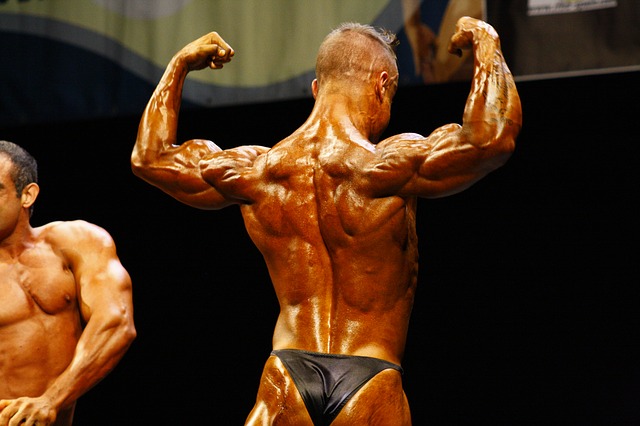 A greased up, tanned, male bodybuilder wearing a thong
