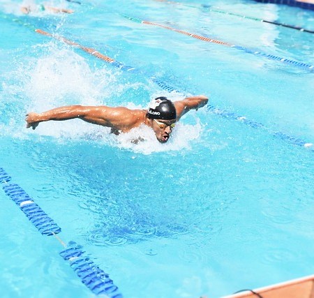 A man performing the butterfly swimming stroke in a pool