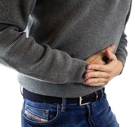 A man clutching his stomach in pain