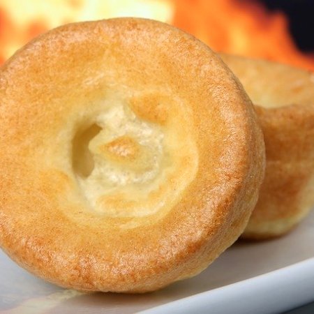 Two Yorkshire puddings with fire in the background