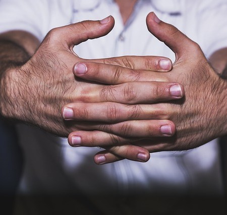 A man holding his knuckles out to crack them
