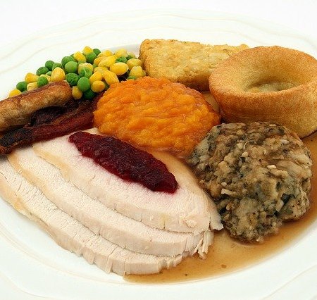 A roast dinner with gravy around the base of the plate