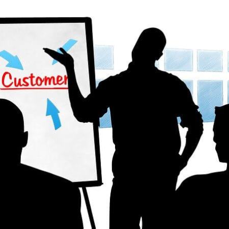 Businessmen discussing customers around a customer chart