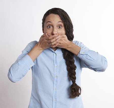 A woman holding her mouth after hiccuping