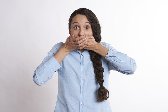 A woman holding her mouth after hiccuping