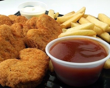 Chicken nuggets with a small ramekin of BBQ sauce