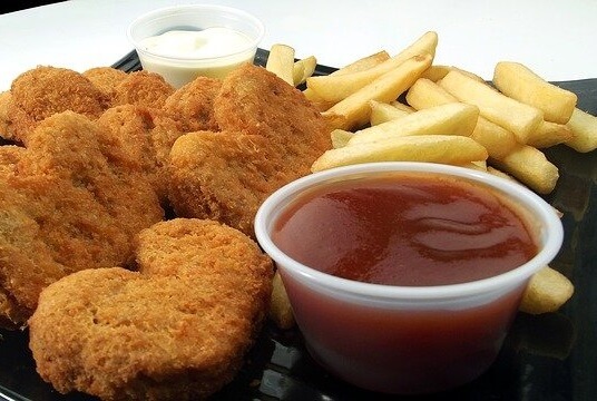 Chicken nuggets with a small ramekin of BBQ sauce