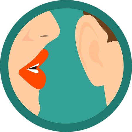 A woman with lipstick gossiping in a man's ear