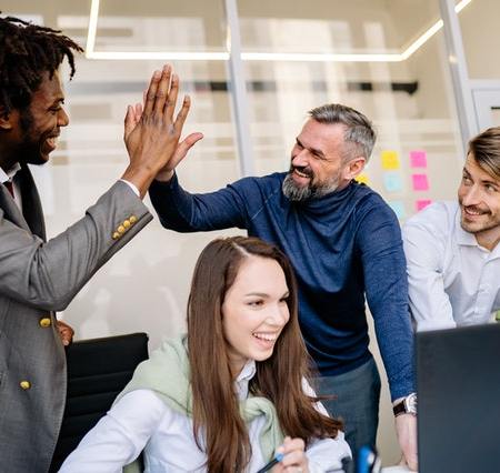Employees celebrating in an office by not pushing each other