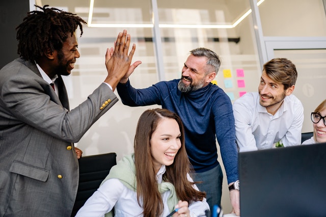 Employees celebrating in an office by not pushing each other