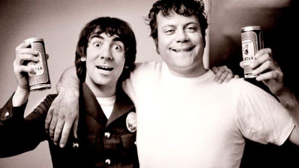 Keith Moon and Oliver Reed hugging and having a drink